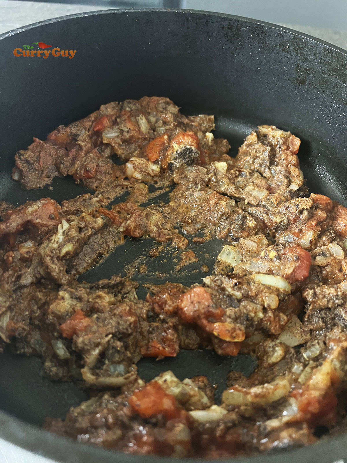 Adding the chopped tomatoes to the pan