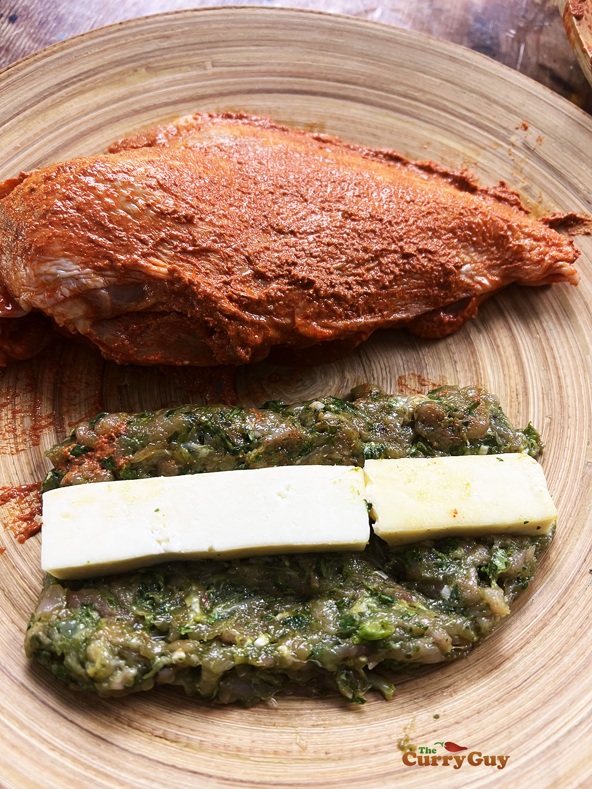 Marinated chicken breast next to the stuffing mixture.