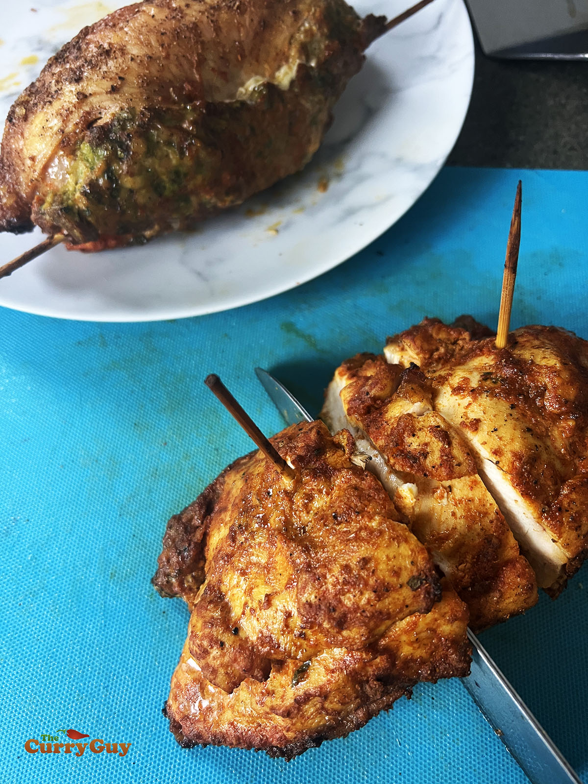 Cooked chicken breasts being sliced.