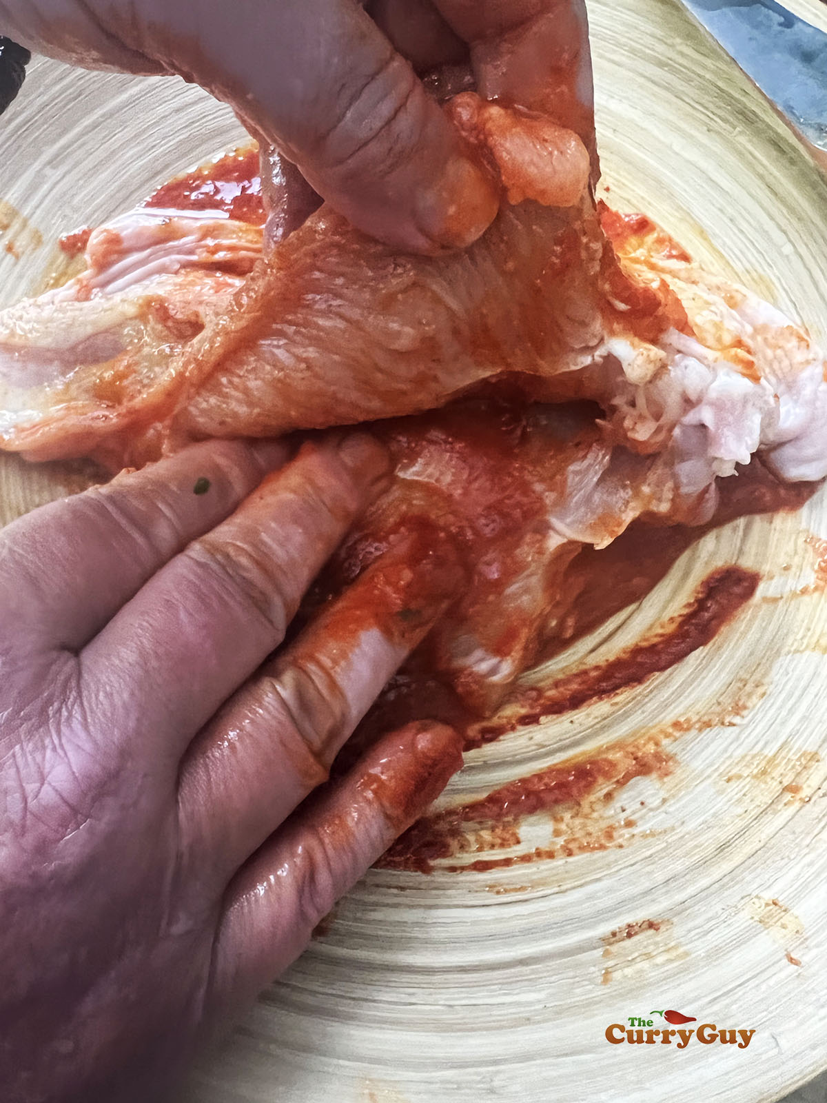 Rubbing the first marinade over the chicken breasts.