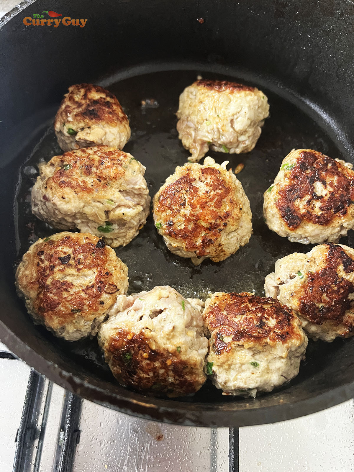 Browning the koftas in a pan.