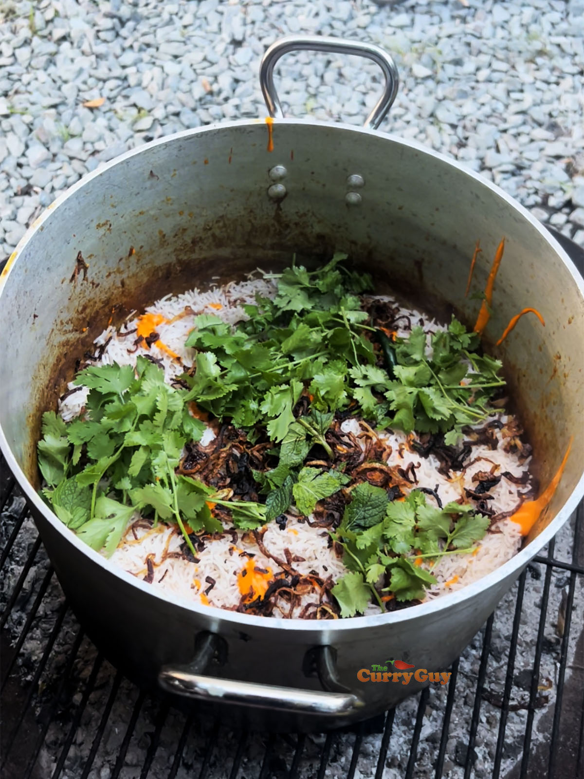 First layer of the biryani with rice, herbs and fried onions. 