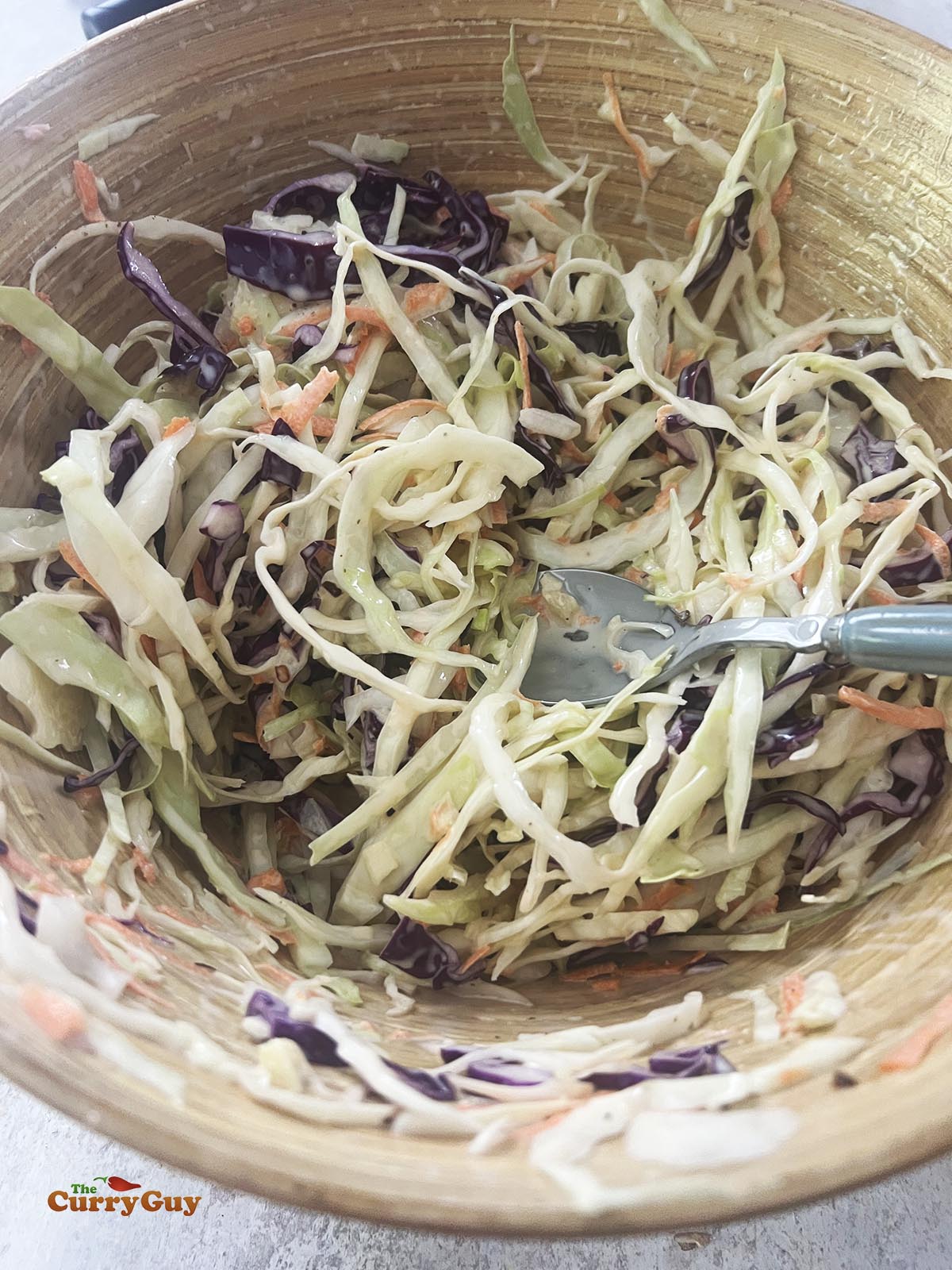 Adding the vegetables to the dressing. 