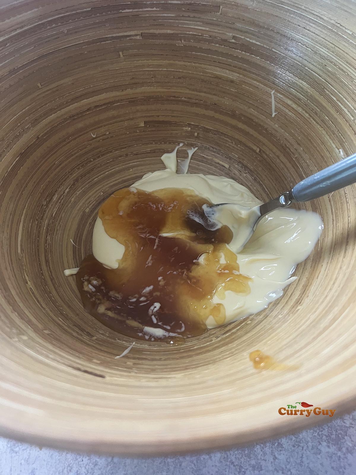 Mixing mayonnaise and honey together to start the coleslaw dressing.