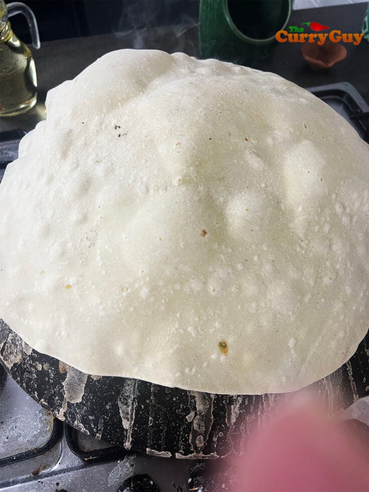 rumali roti turned and cooking on a hot wok.