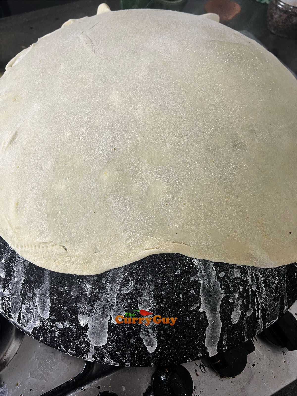 Placing the rolled roti onto the wok.