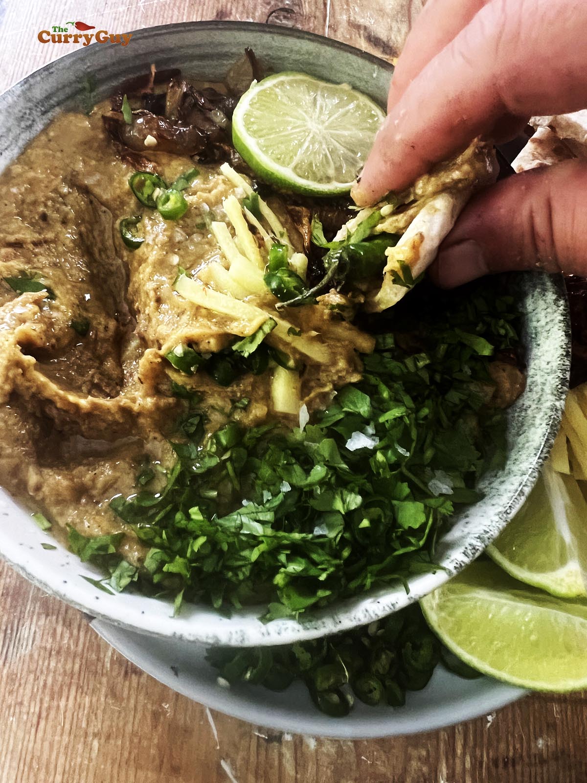 Eating haleem with a naan.