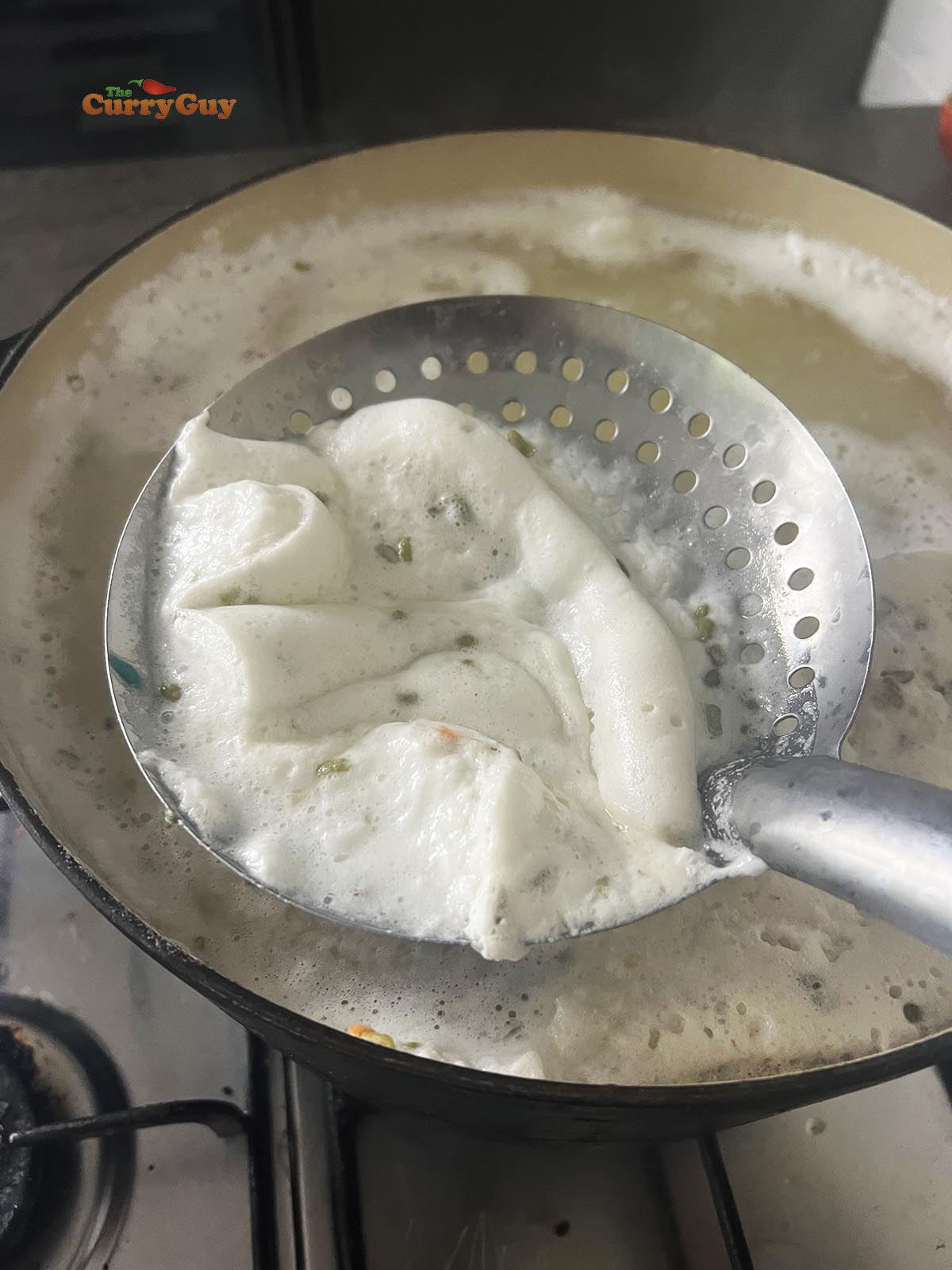 Skimming foam off the cooking lentils.