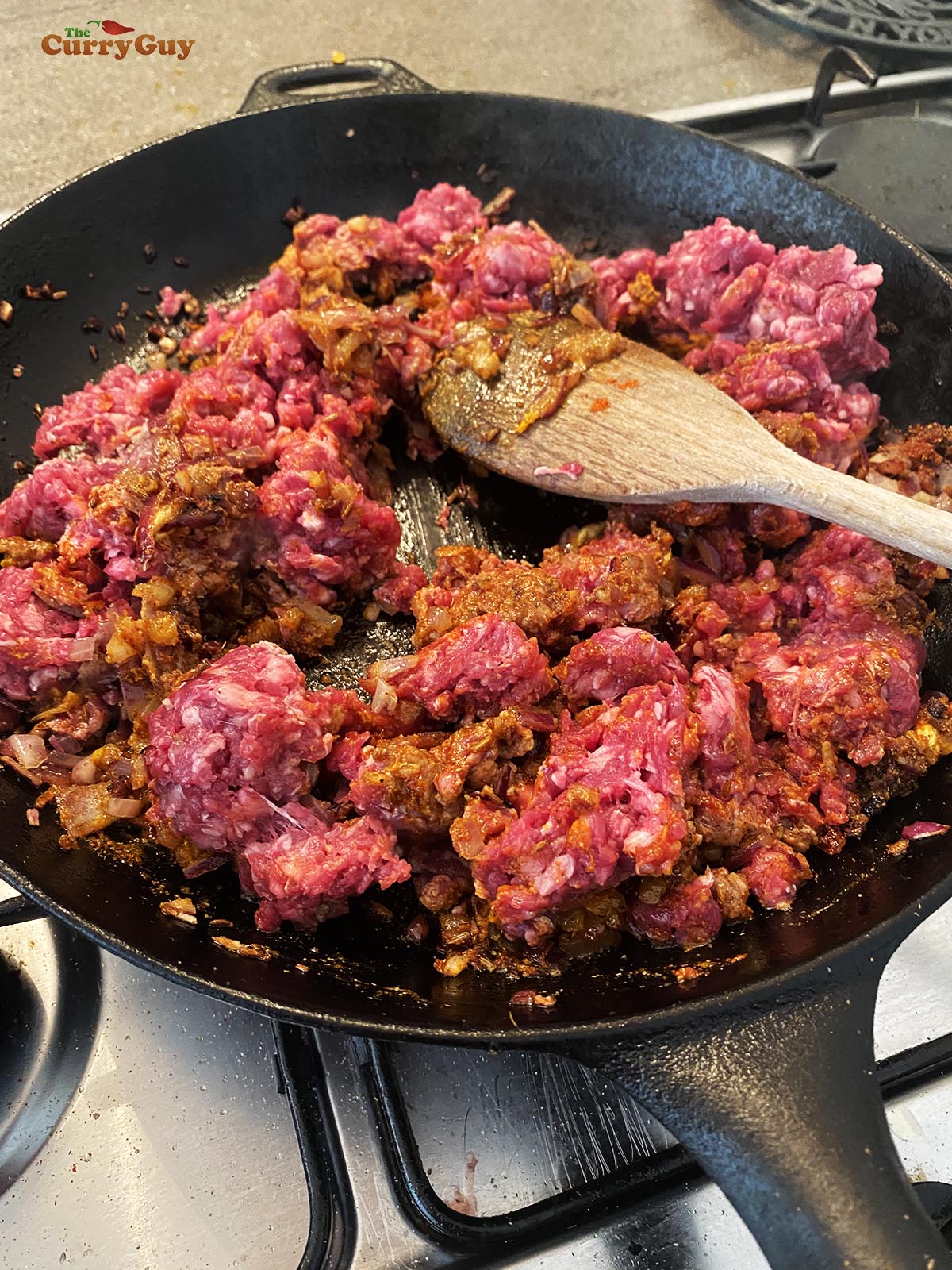 Adding the minced lamb to the pan.