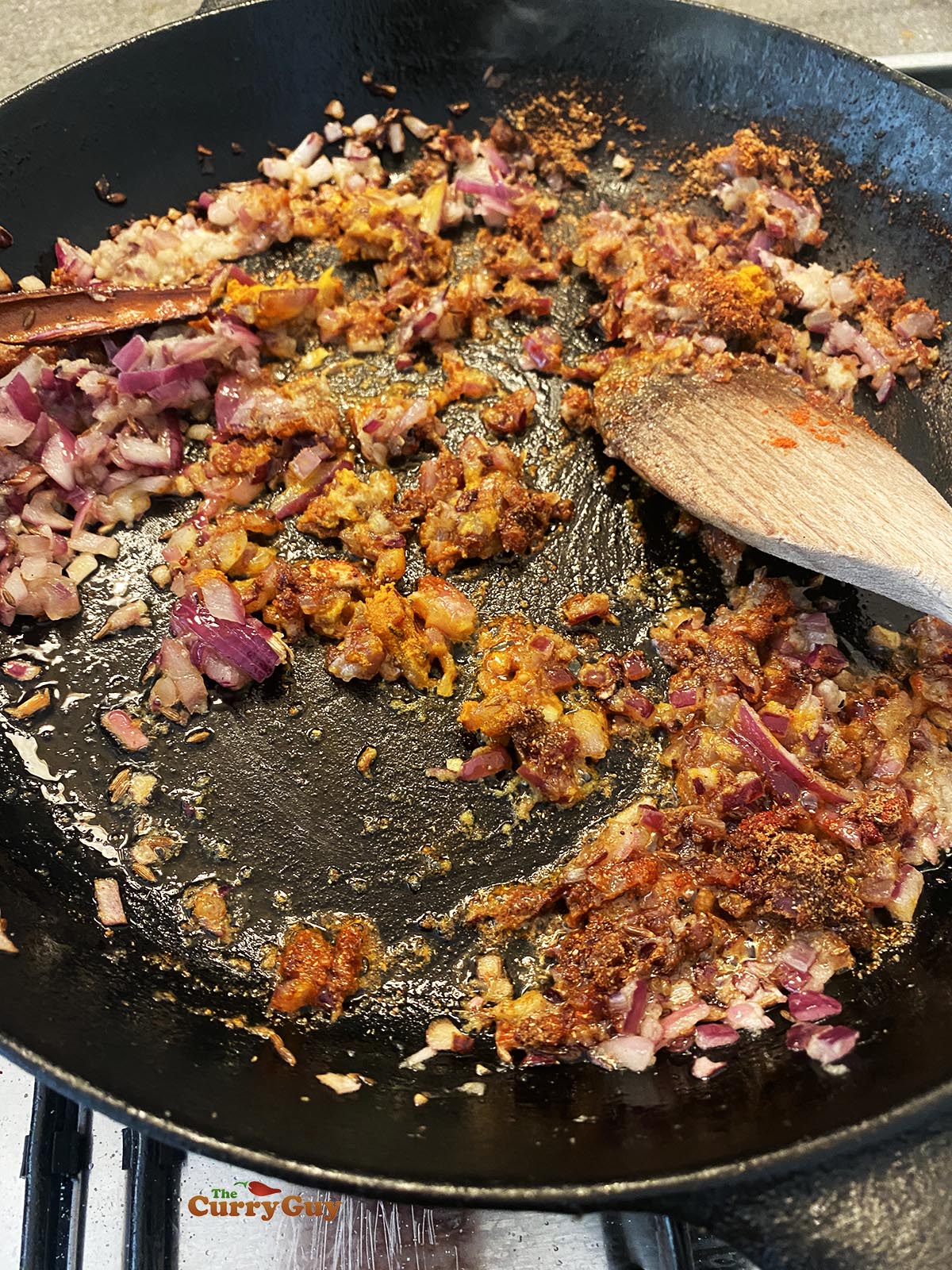 Adding ground spices to the fried onion mixture.