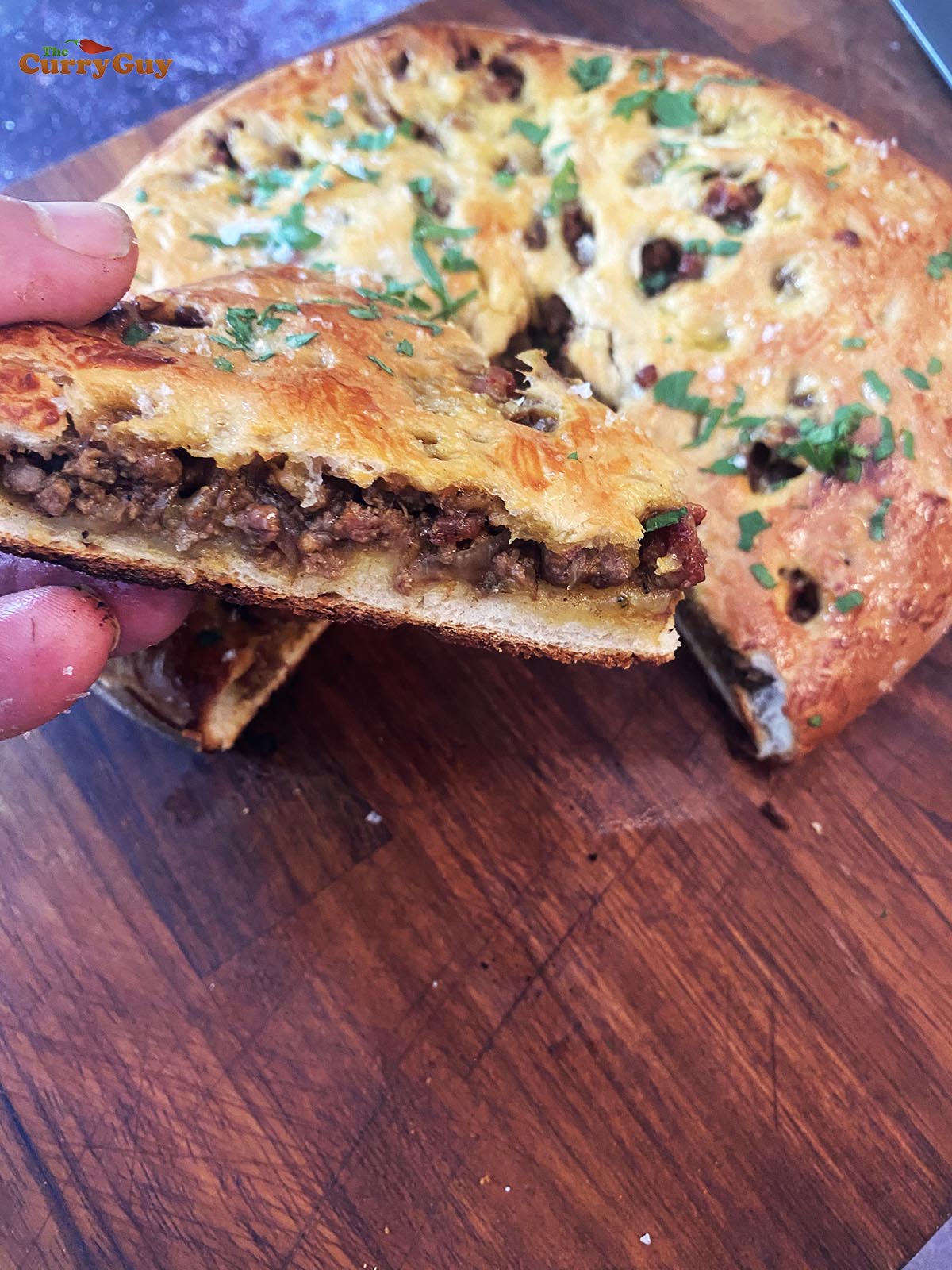 Holding a slice of the keema stuffed naan.