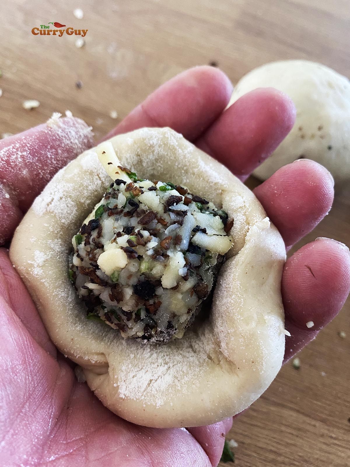 Forming stuffed kulcha dough balls.