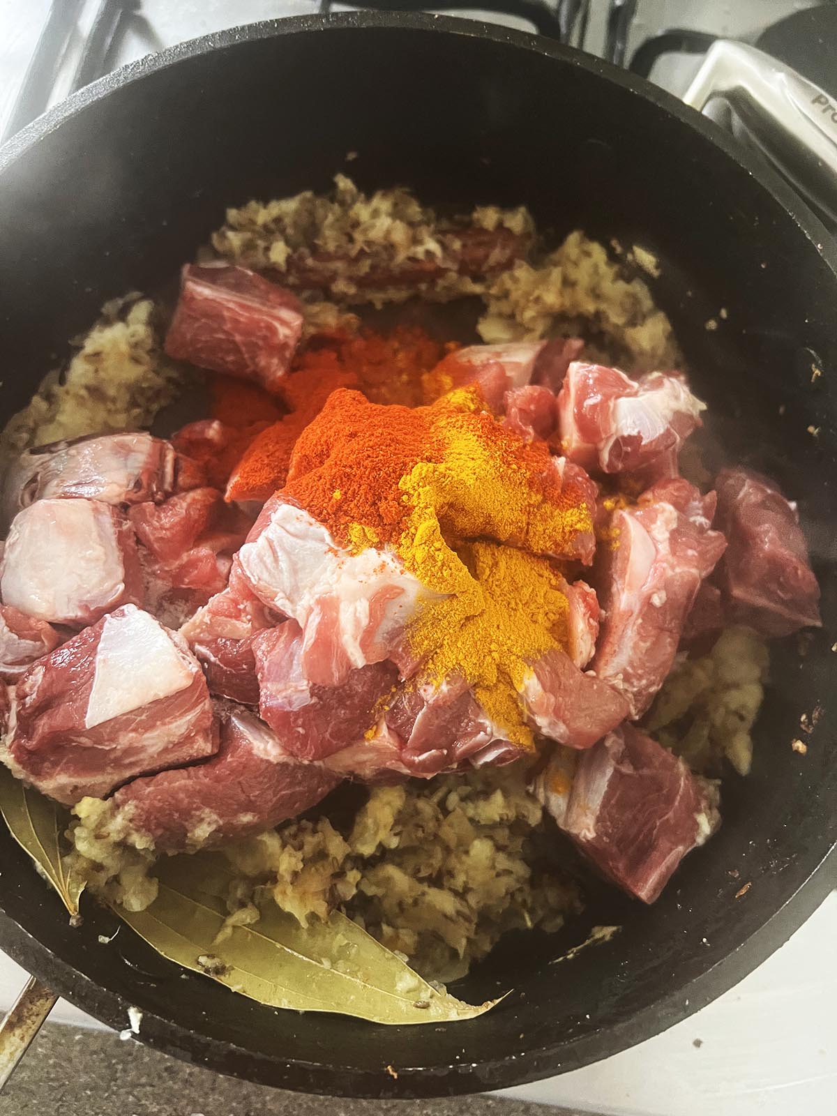 Adding the meat and ground spices to the pan.