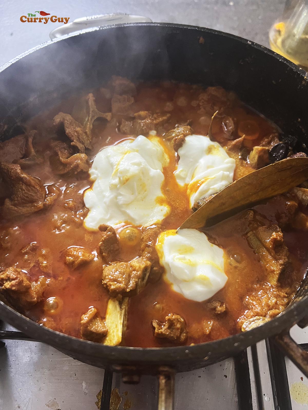 Adding yoghurt to the pan to thicken the sauce