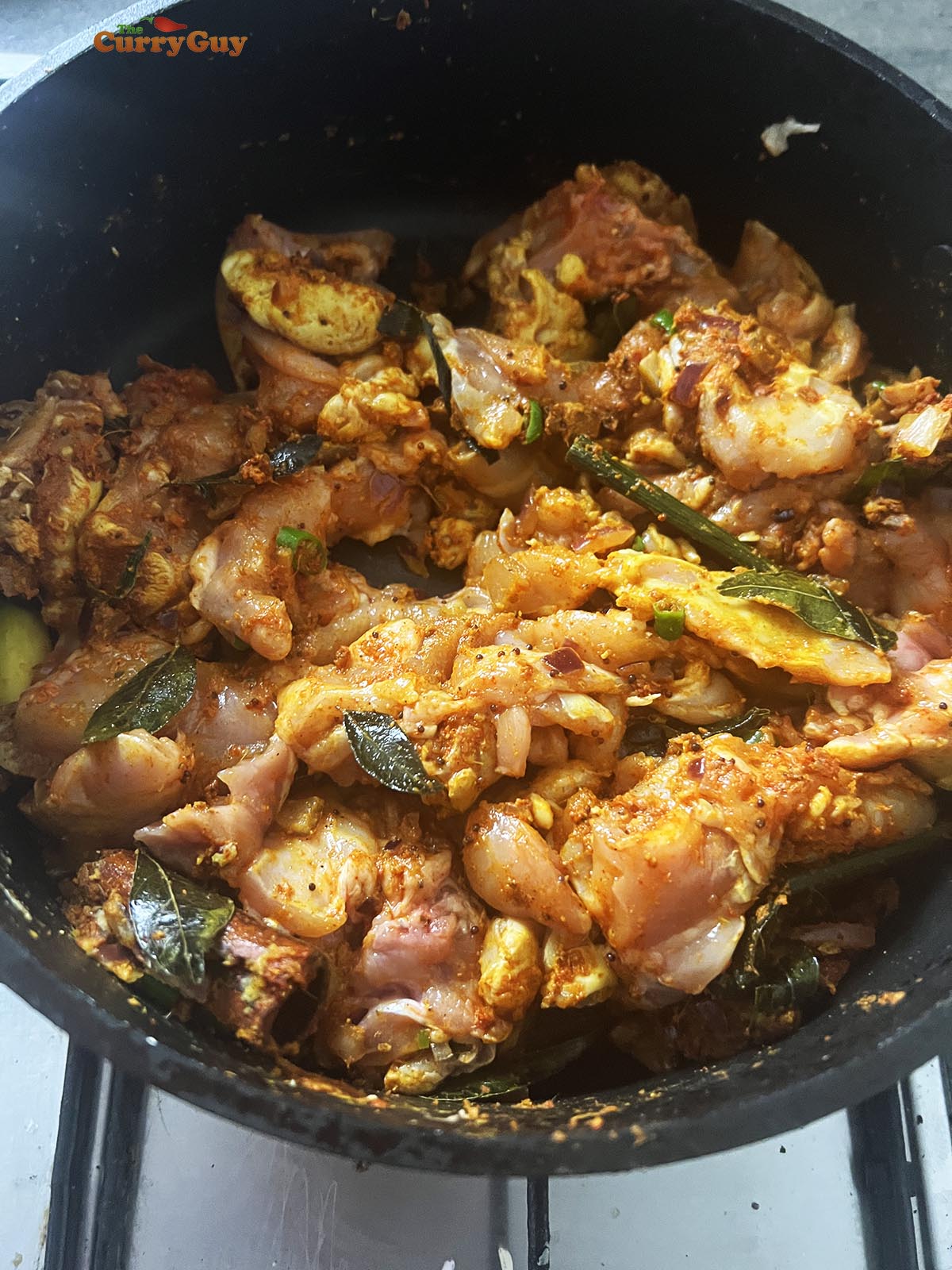 Stirring the chicken pieces into the pan.