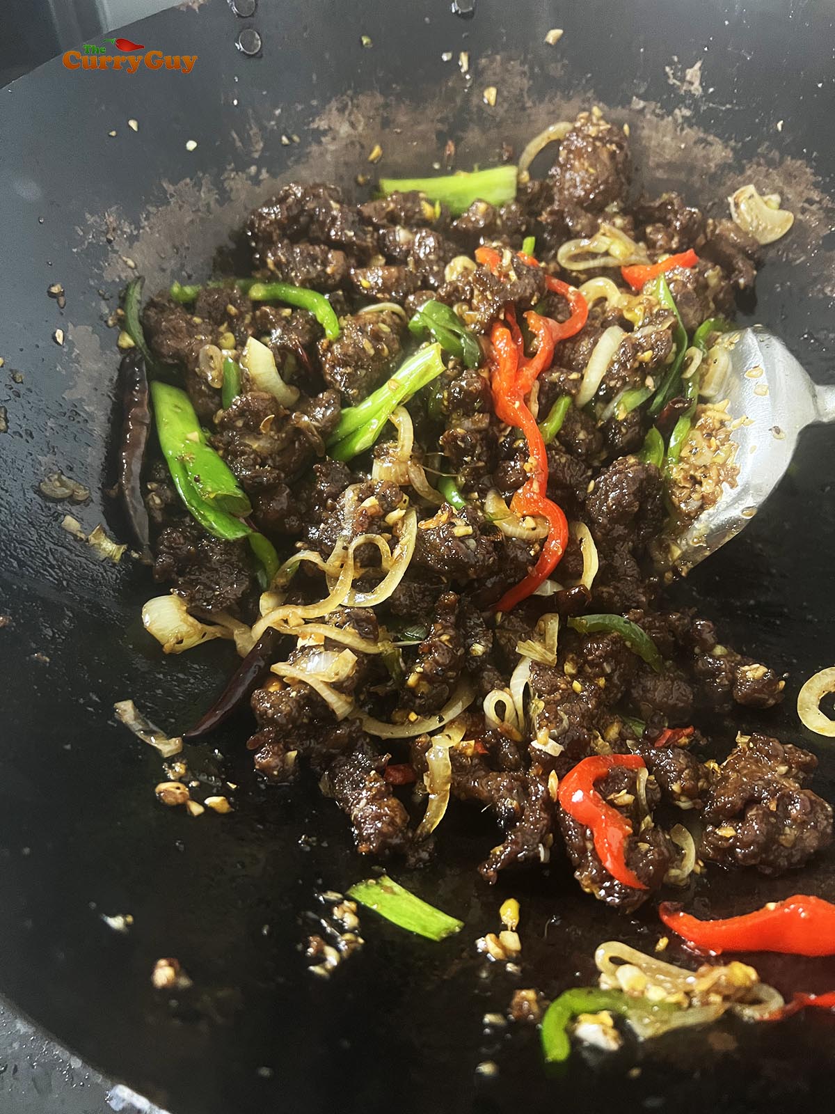 Stirring the sauce into the meat. 