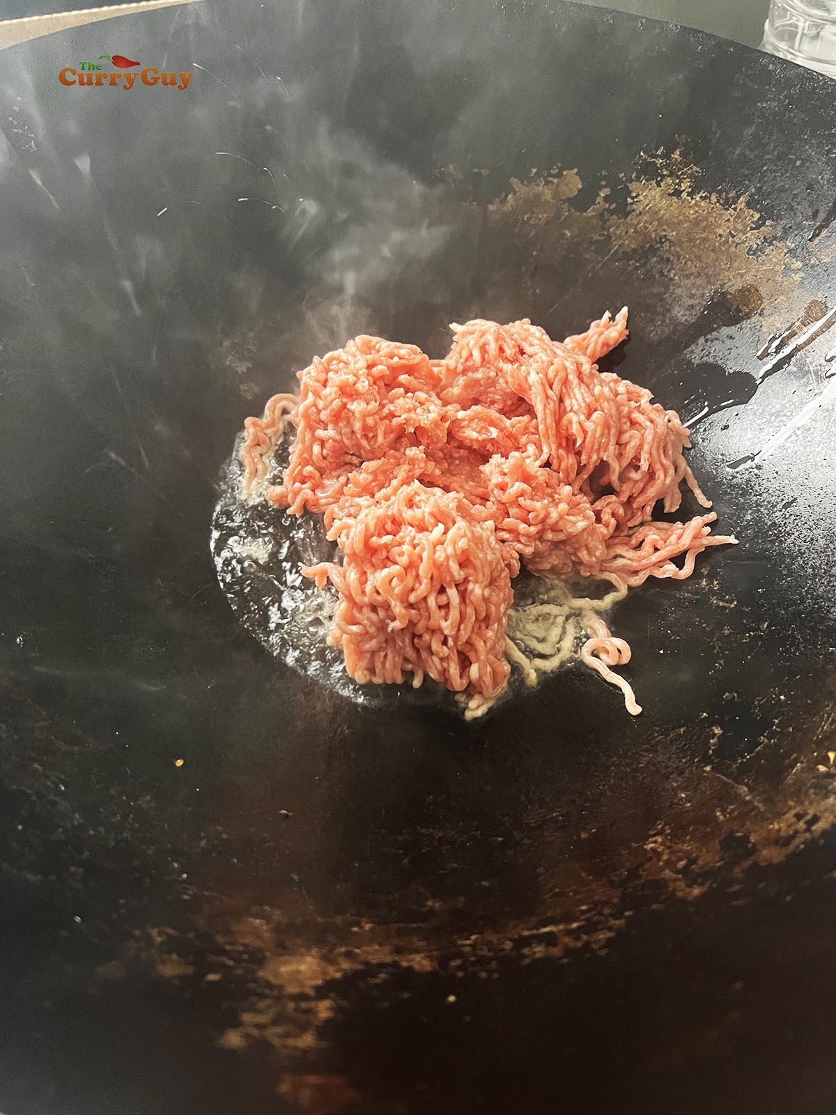 Frying the pork in a wok.