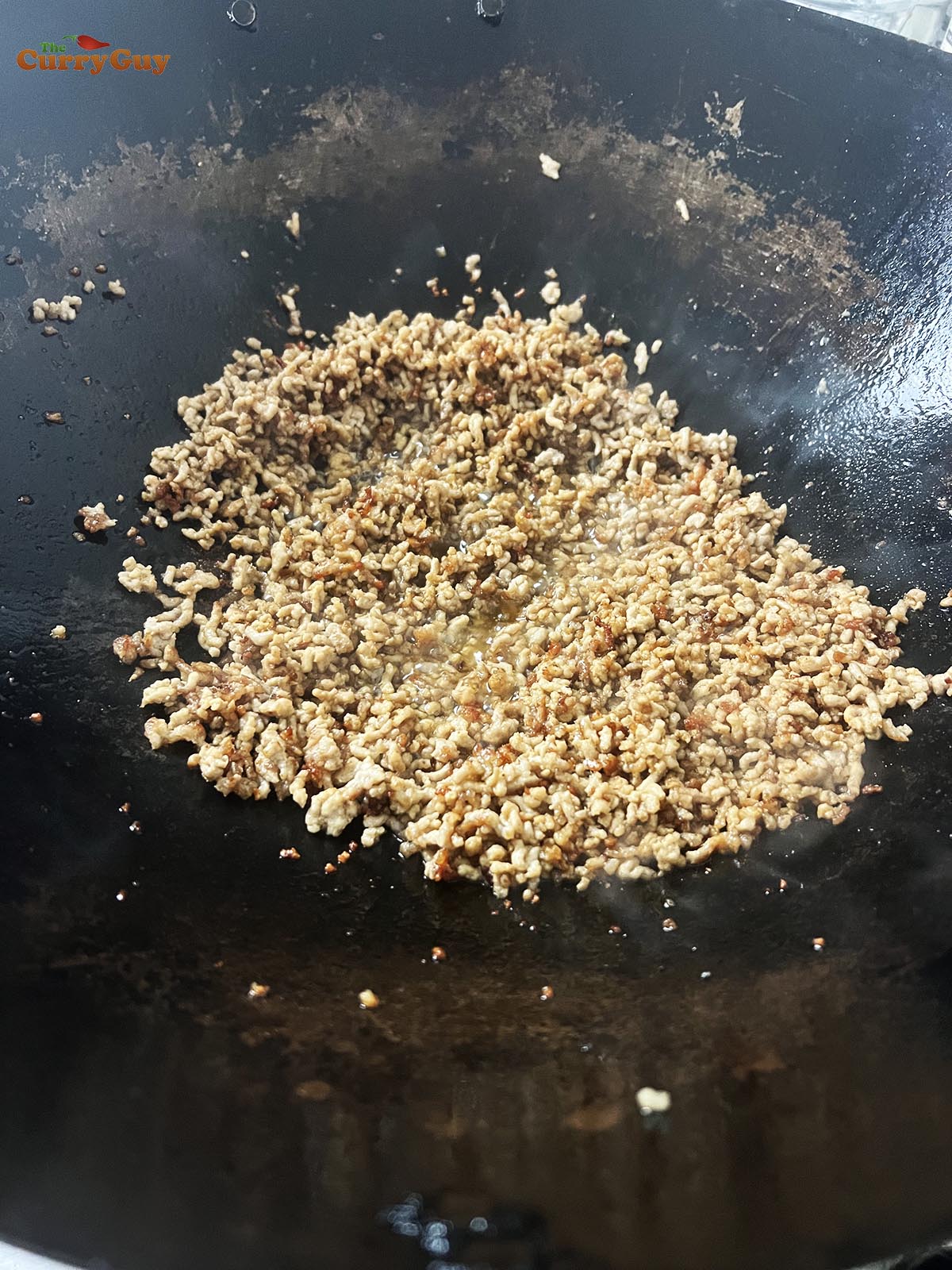 Frying the pork until crispy.