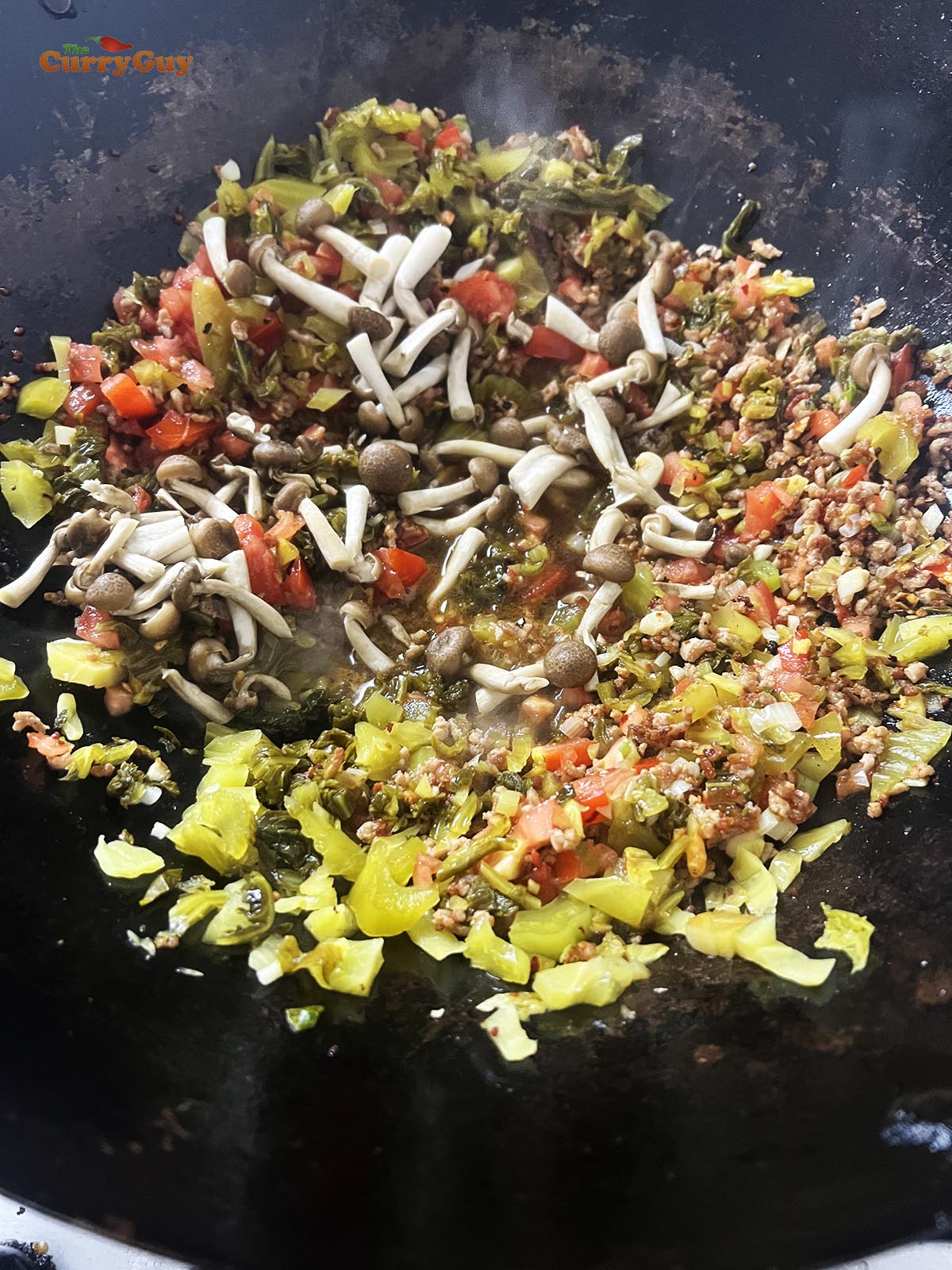 Adding the mushrooms to the wok.