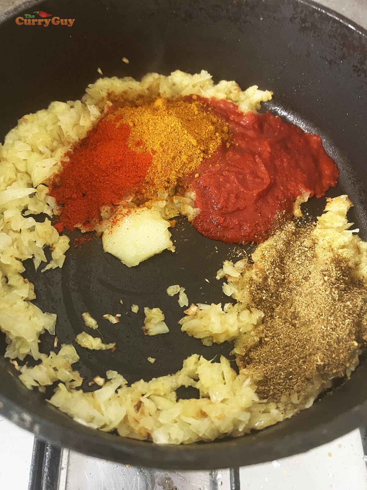 Adding the ground spices to the pan.