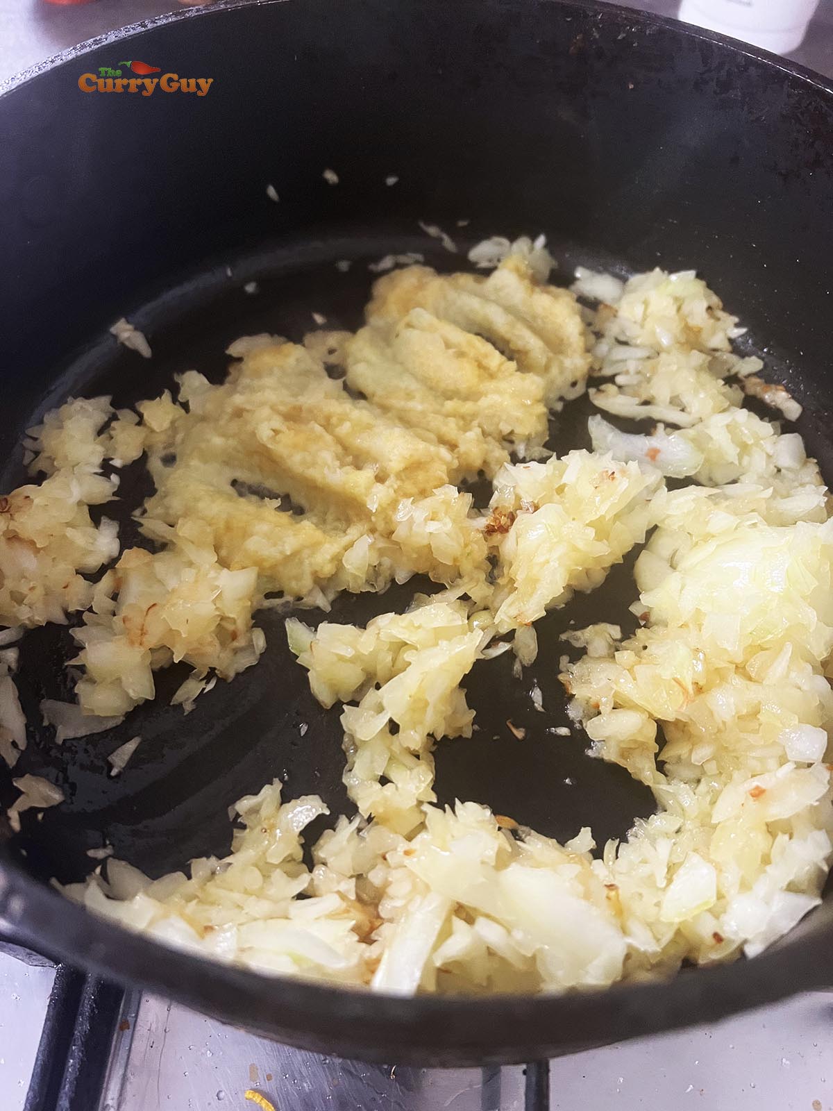 Adding garlic and ginger paste to the chopped onions.