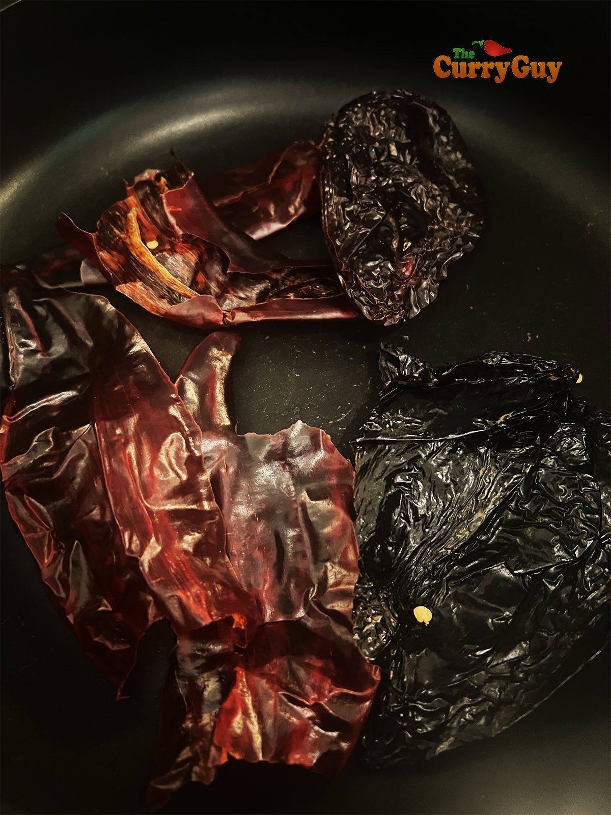 Toasting dried chilies in a dry frying pan.