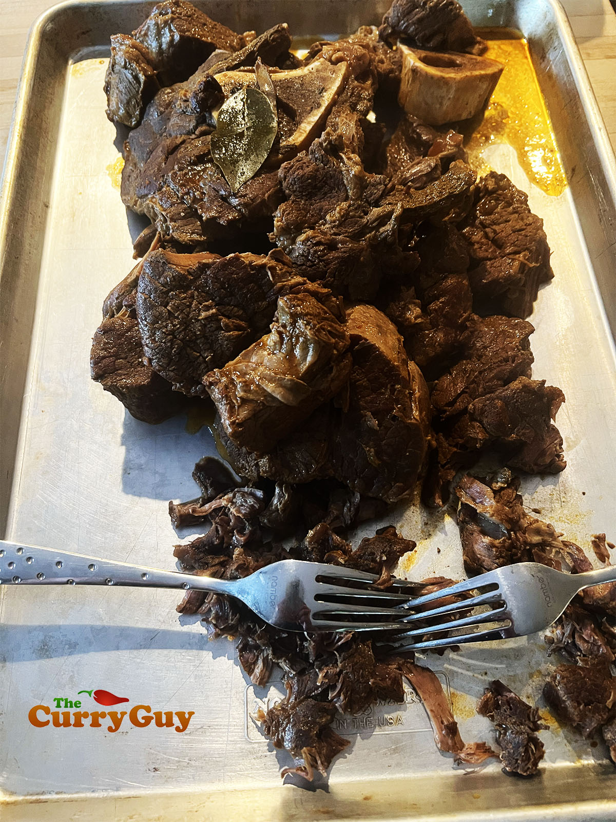 The cooked meat ready for shredding on a clean work surface.