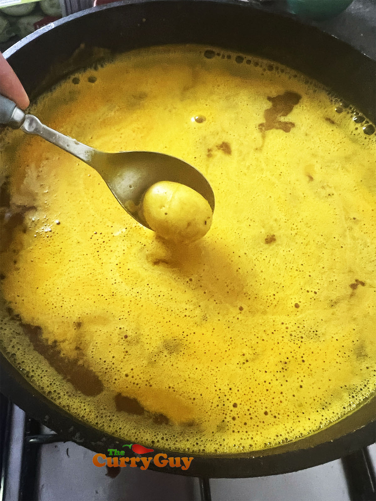 Simmering the potatoes in turmeric water.