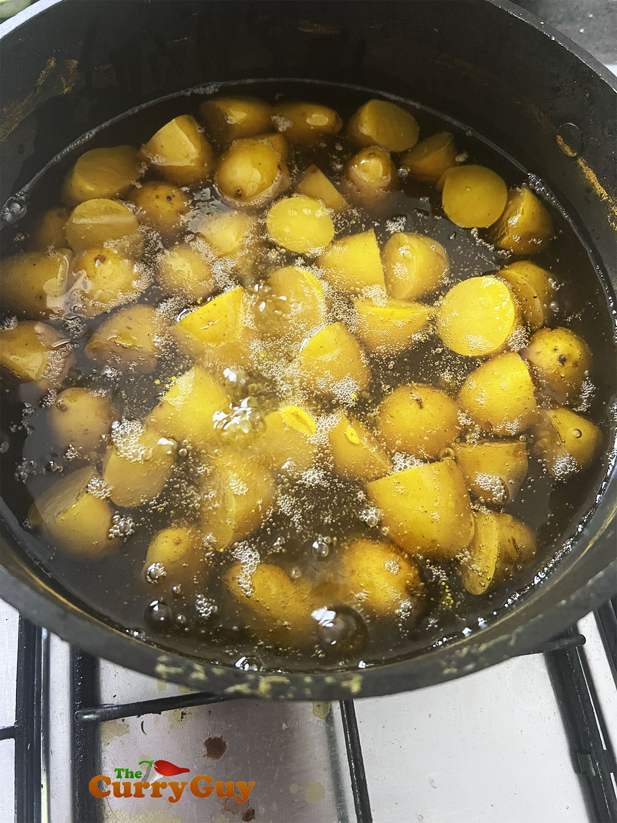 Frying the par-cooked potatoes to crisp them up.