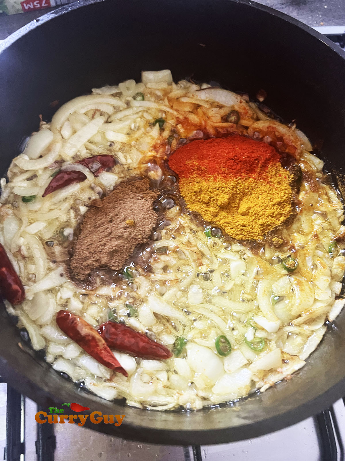 Adding the ground spices to the pan.