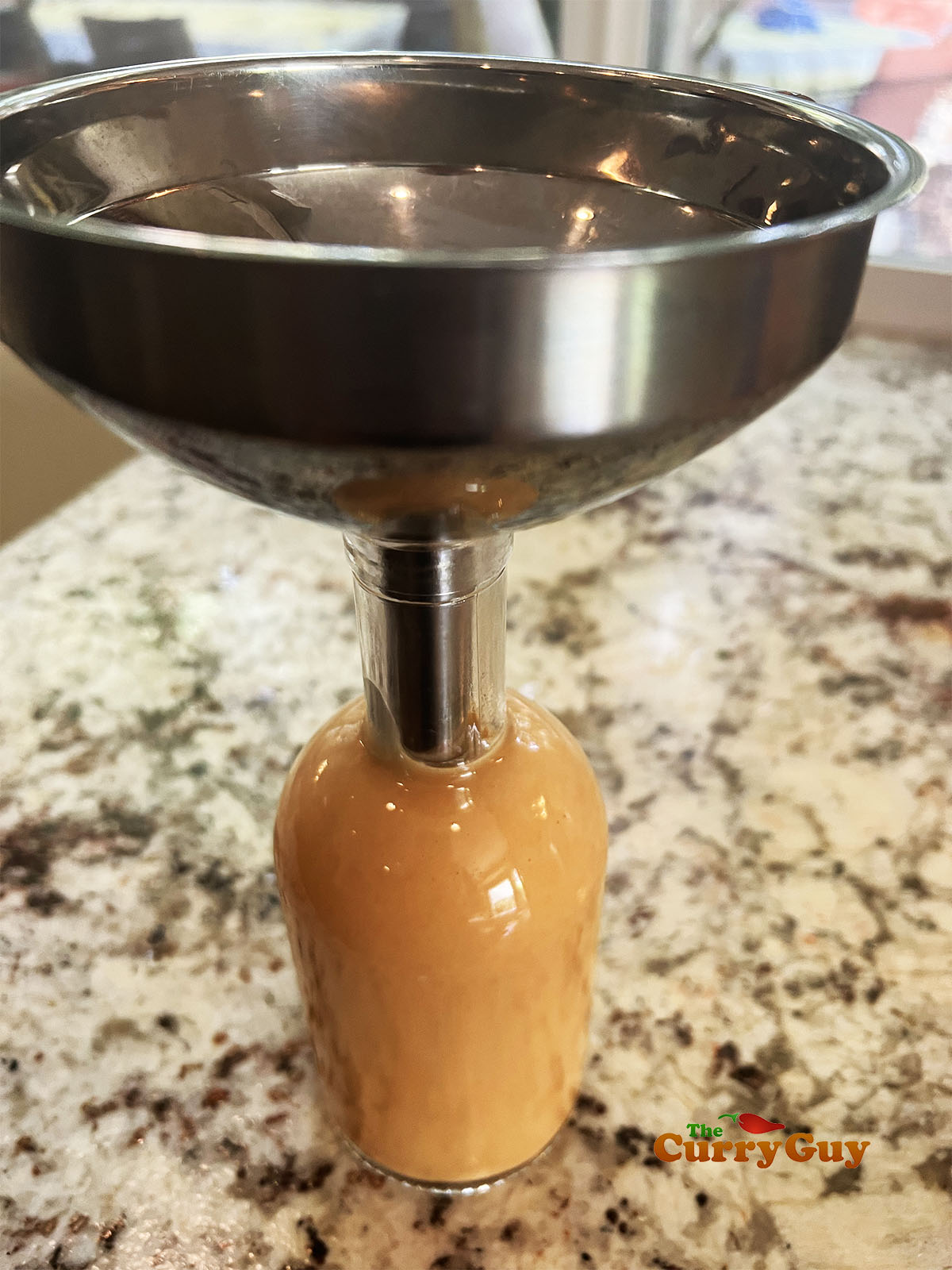 Pouring the hot sauce into a bottle.