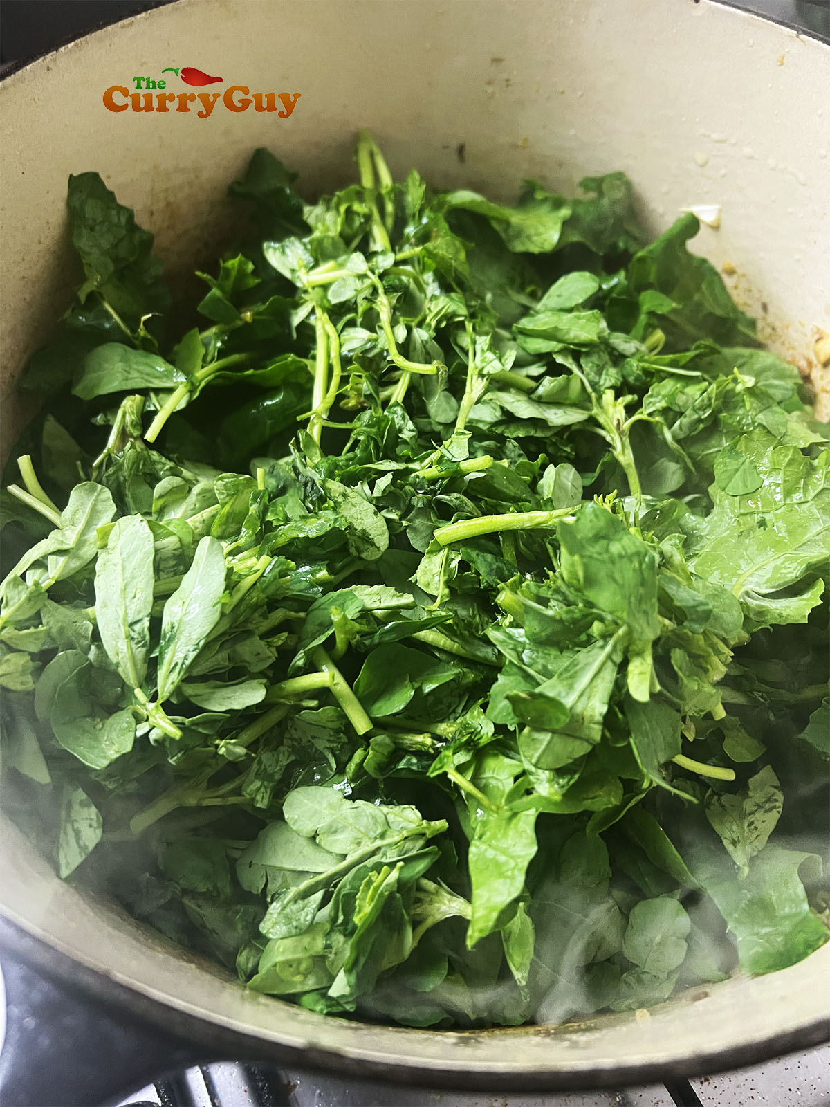 Adding the green, leafy vegetables to the pan