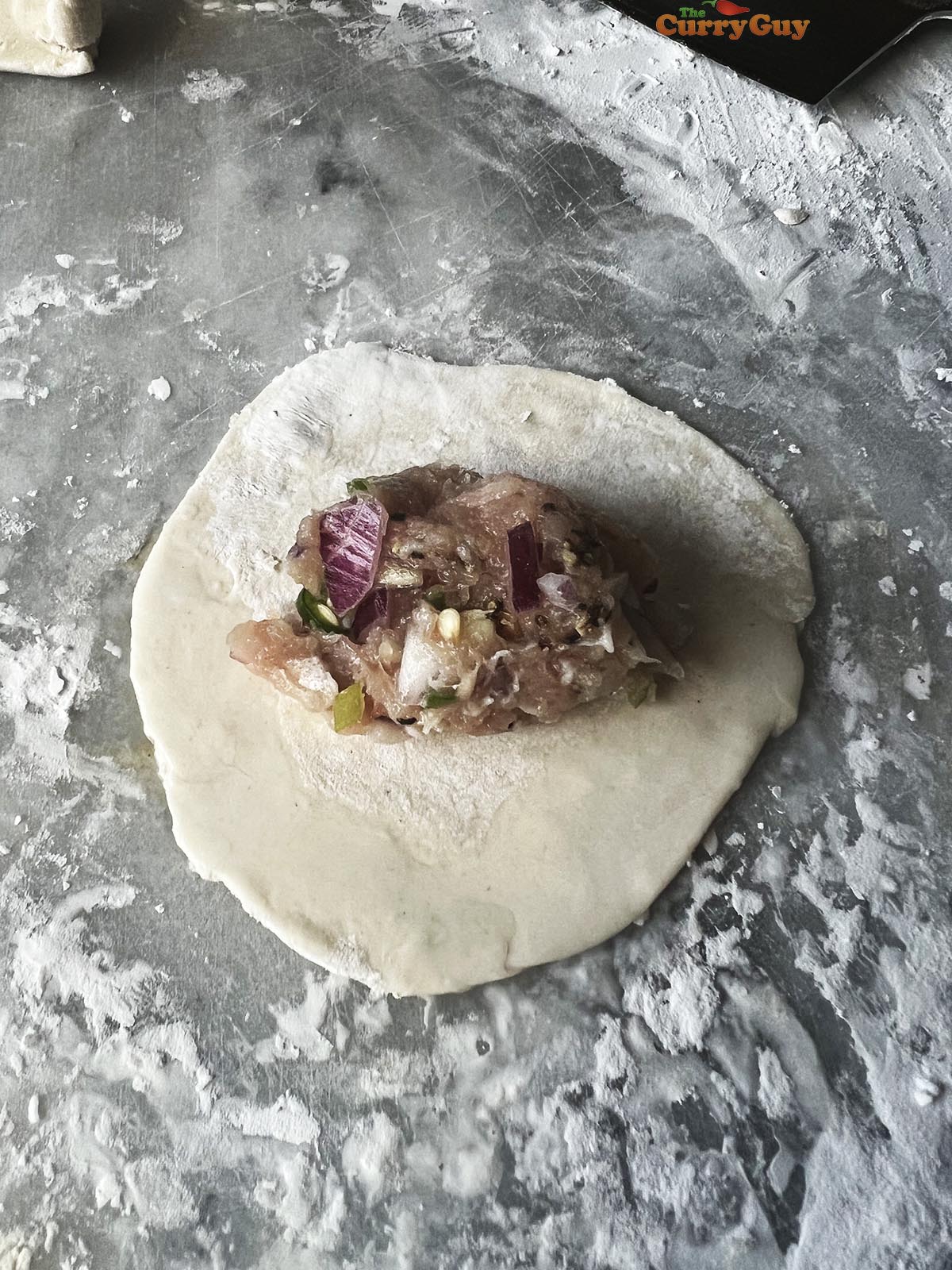 The meat mixture on top of a momo wrapper