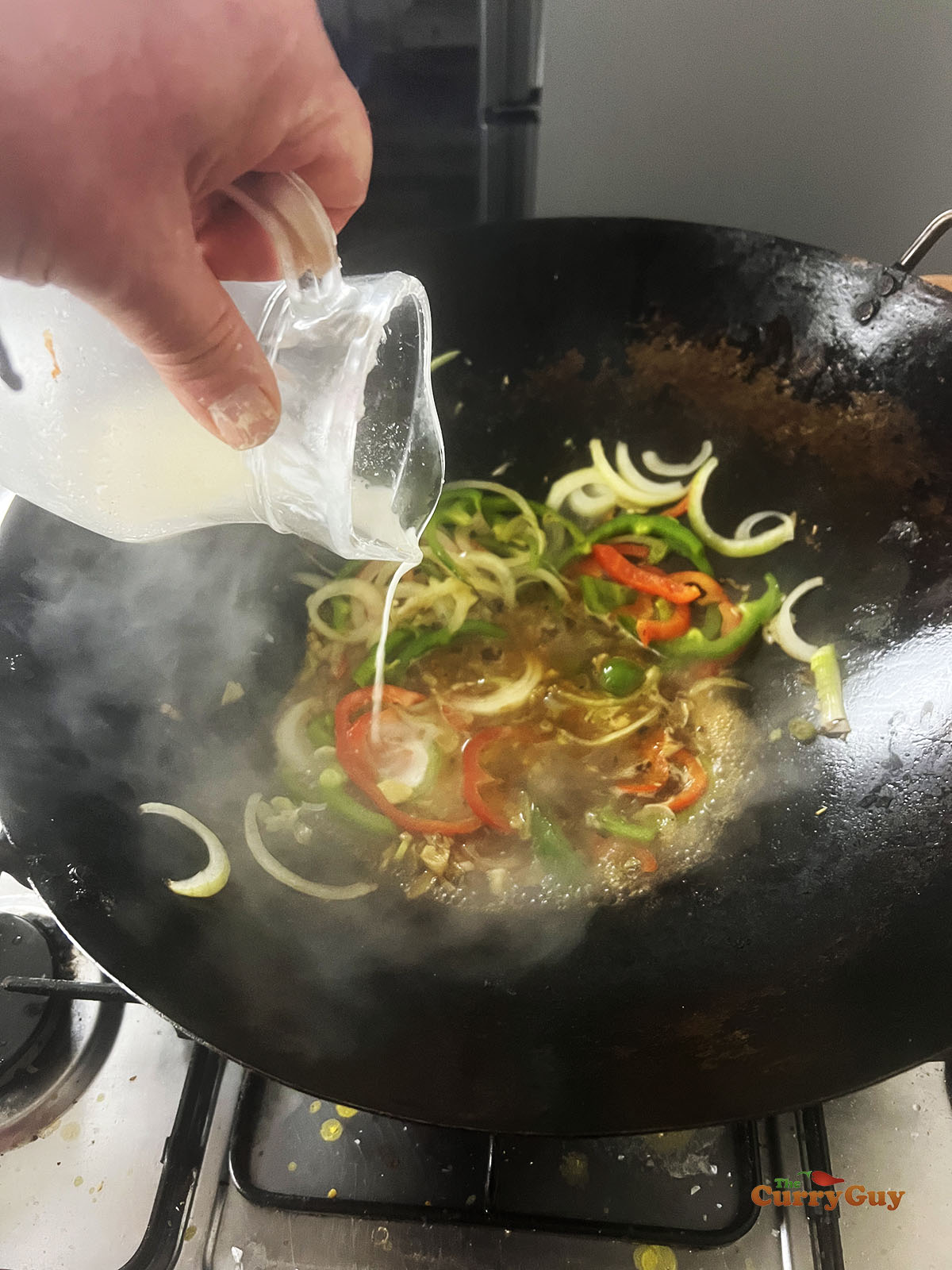 Adding a slurry to the sauce.