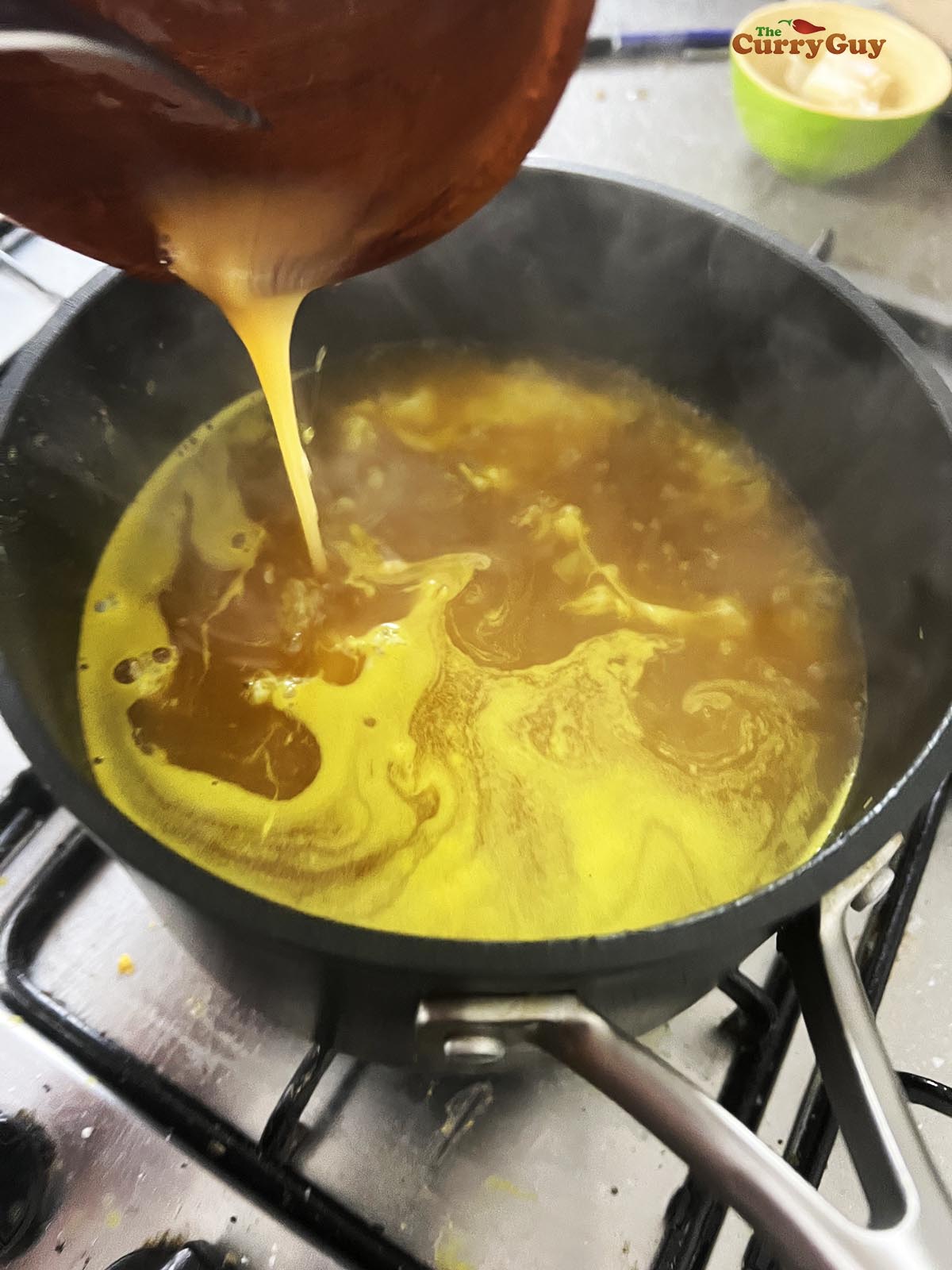 Adding the egg to the soup. 