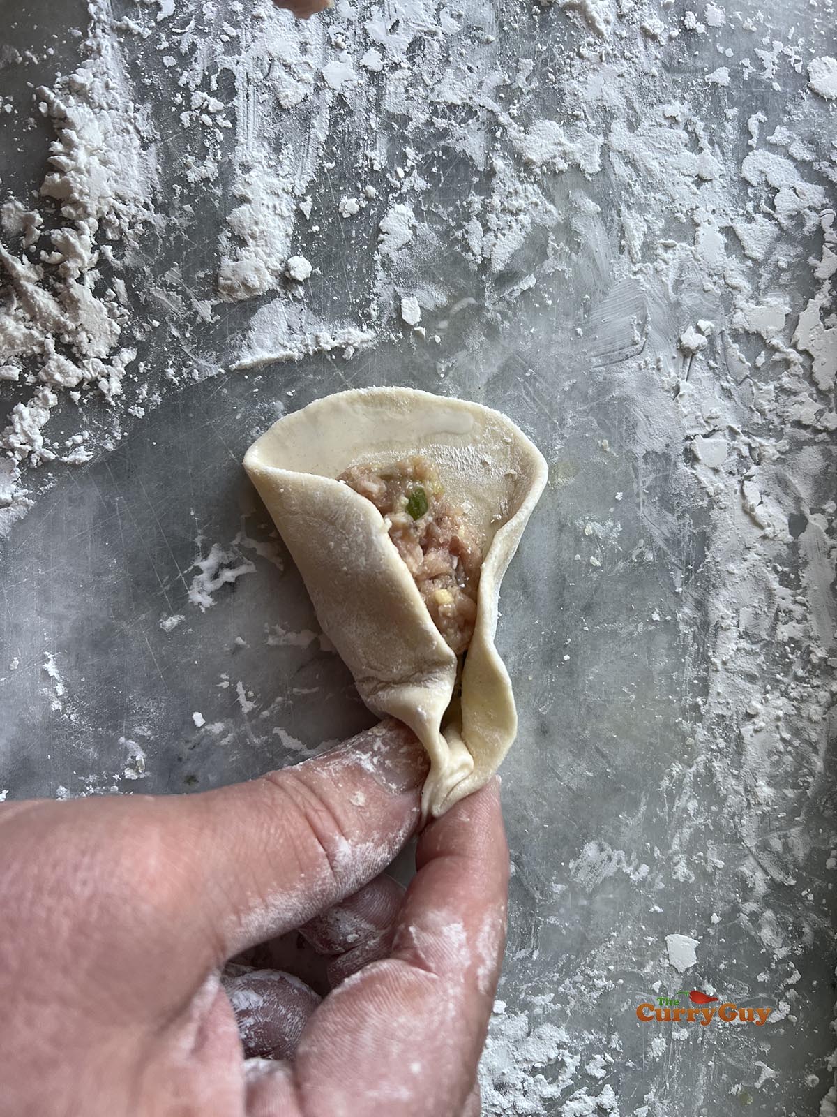 Pleating the potstickers closed.