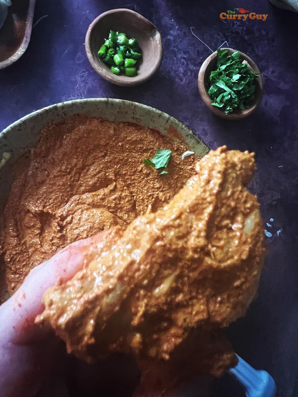 Coating the momos with tandoori marinade.