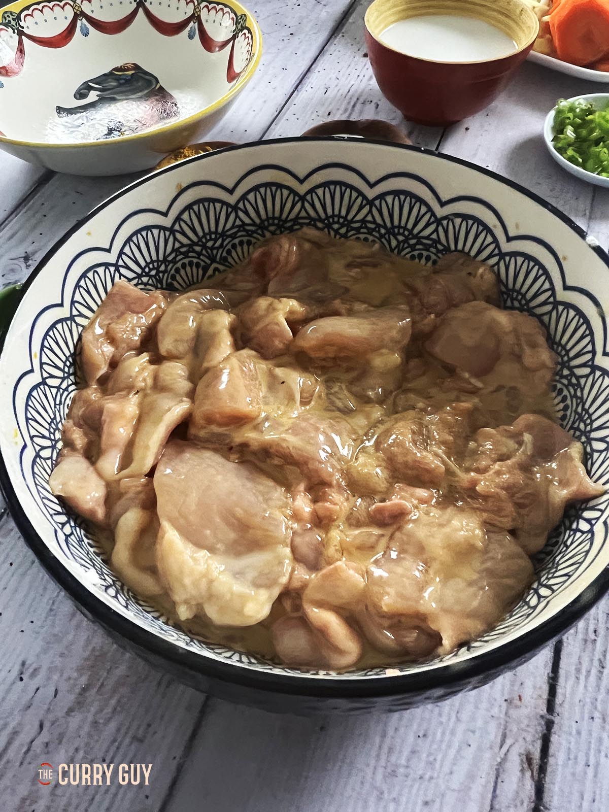 The chicken marinating in a bowl.