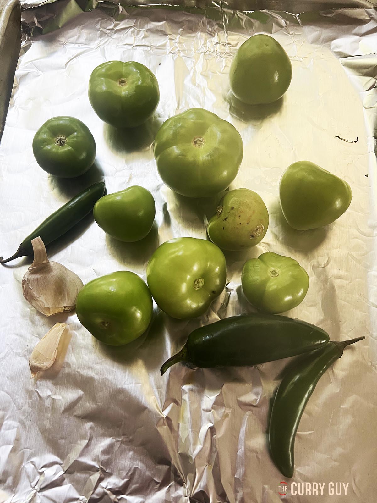 The tomatillos, chilies and garlic on a backing tray, ready for roasting.