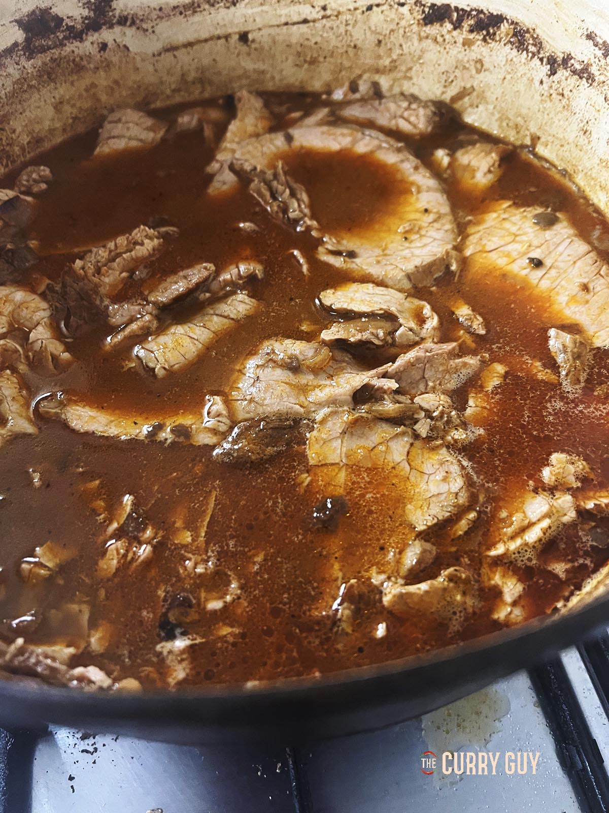 The sliced meat in the hot broth.