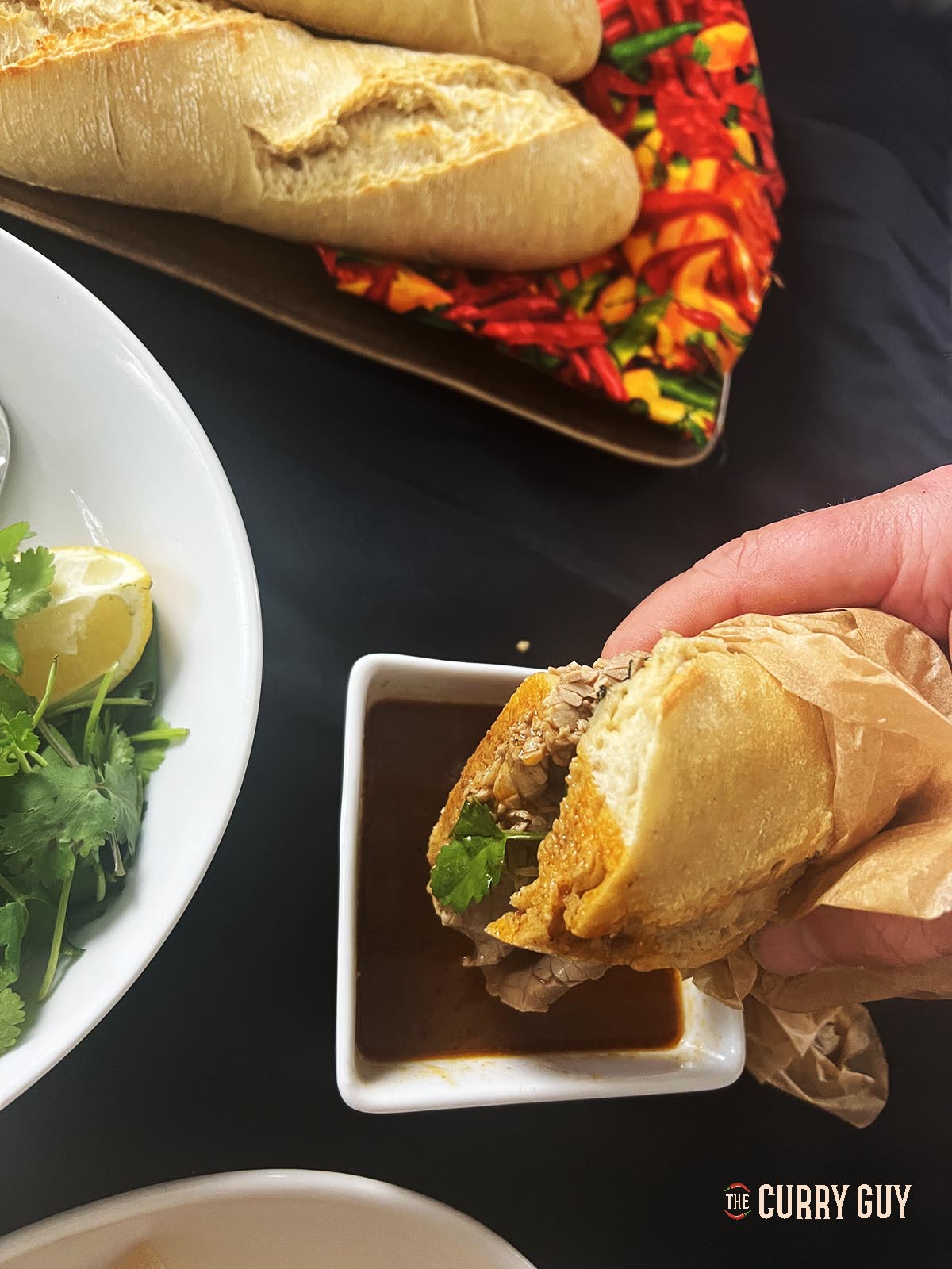 Dipping a beef sandwich in the broth at the table.