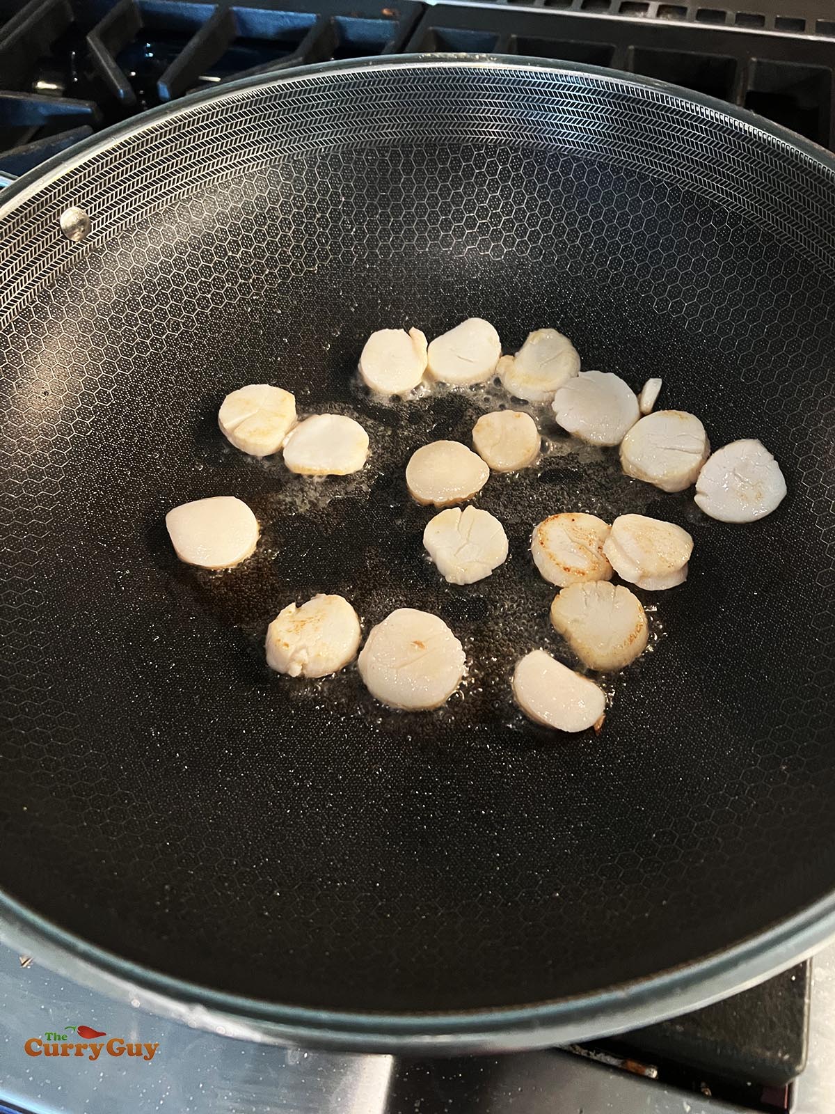 Frying the scallops in a wok. 