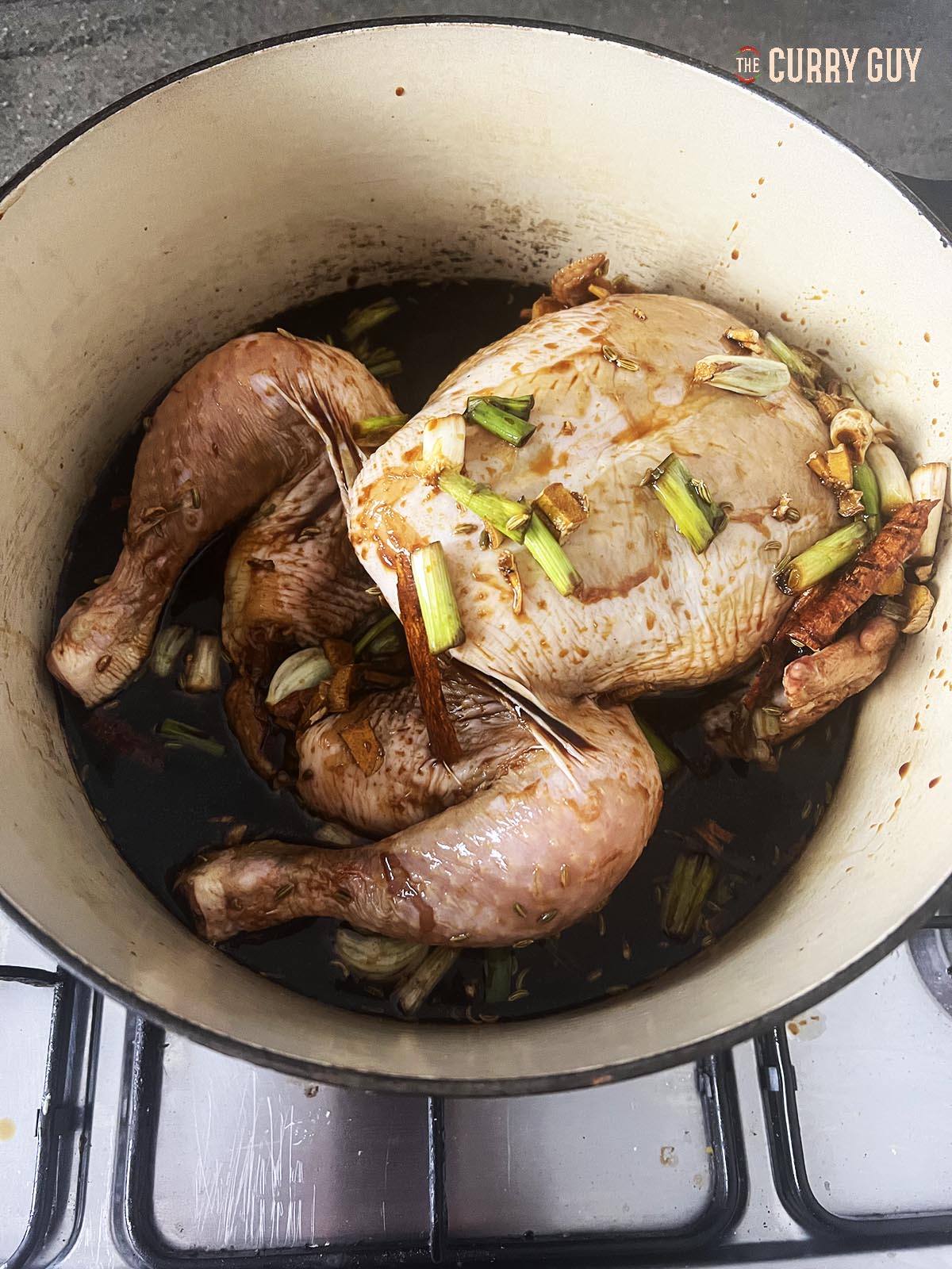 The chicken and marinade in a pot. 