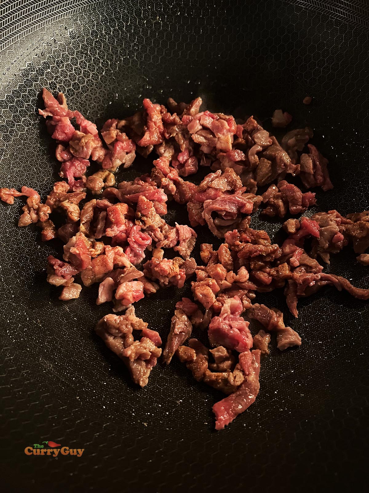 Frying some of the marinated steak meat.