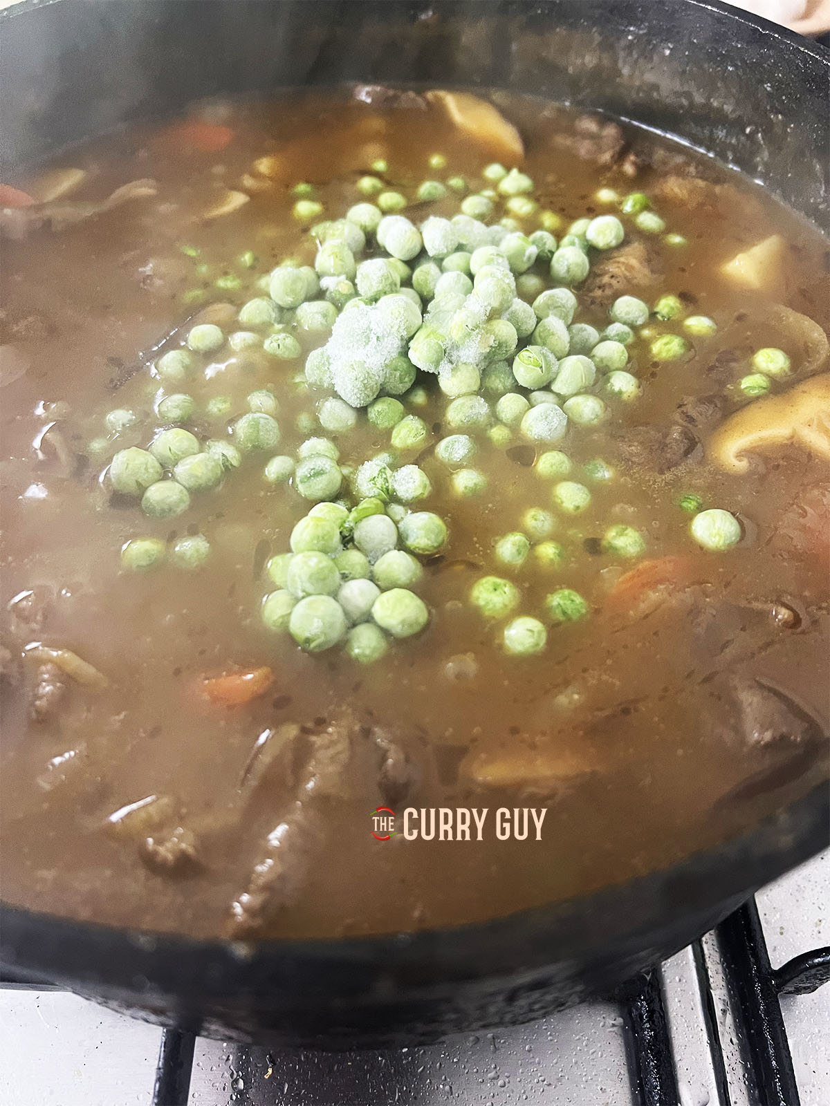 Simmering the sauce and adding the peas.