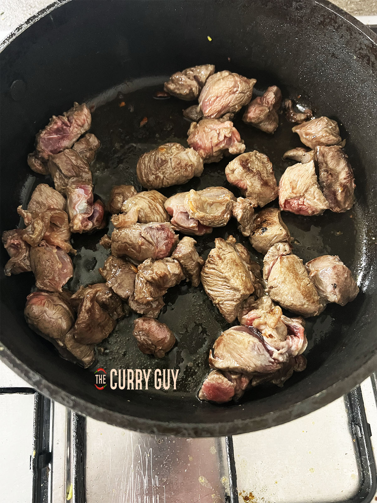 Adding water to the browned meat.