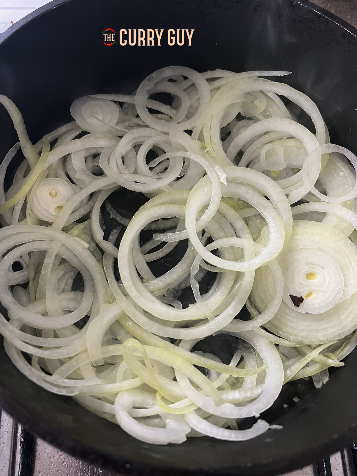 Adding the onions to oil in the pan to fry until soft.