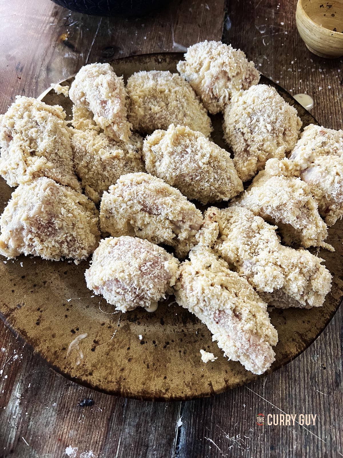 The chicken pieces after being dipped in the Panko breadcrumbs.