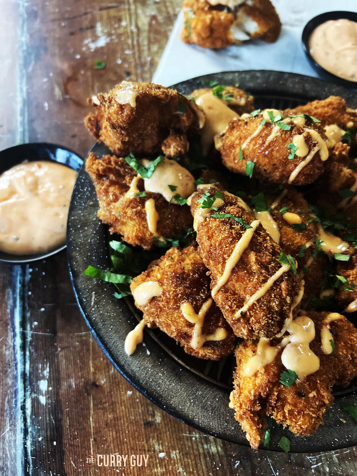 The finished bang bang chicken garnishes with the sauce and coriander (cilantro).