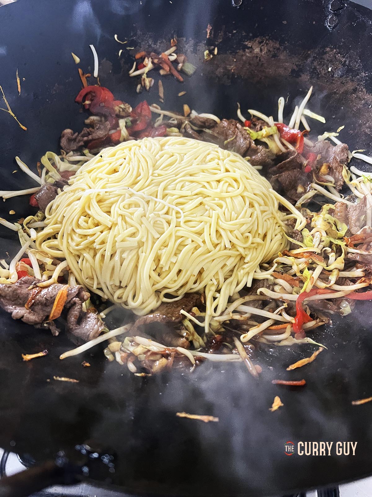 Adding the noodles to the wok.